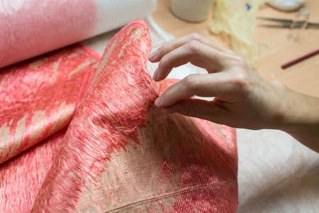 restoration of antique fabrics using silk thread of coral color. Embroidery pattern on fabric using an ordinary sewing needleの写真素材