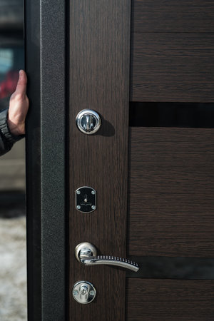 Metal apartment entrance door burglar sdelanaya by special technology. Door metal loop close-up doorknob and keyhole close-upの写真素材