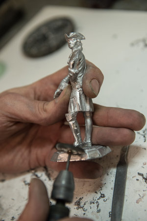 Saint-Petersburg, Russia - February 21, 2017: A small factory producing small batches pewter figurines. The master cleanse warrior figurine from burrsのeditorial素材