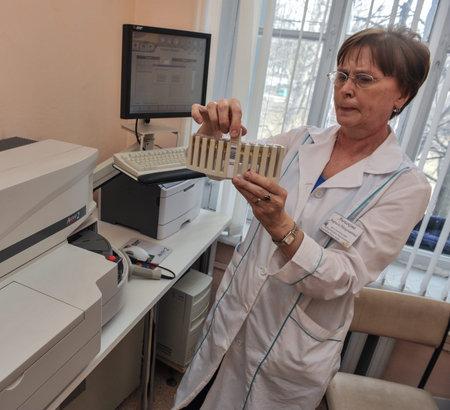 St. Petersburg, Russia - April 15, 2011: Laboratory of the hospital. Biochemist makes the analysis using an automatic biochemical analyzer.のeditorial素材