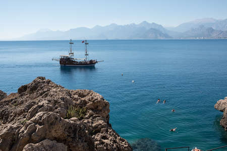 Antalya, Turkey - October 17, 2017: Picturesque beach and coast near the old town of Kaleici. People bathe in the sea against the background of rocks.のeditorial素材