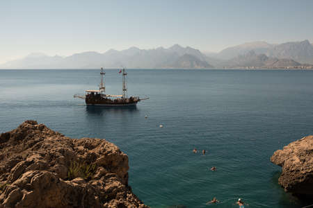 Antalya, Turkey - October 17, 2017: Picturesque beach and coast near the old town of Kaleici. People bathe in the sea against the background of rocks.のeditorial素材