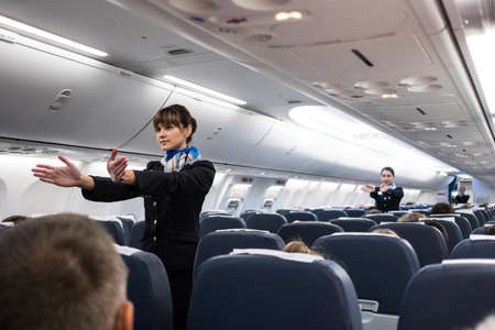 St. Petersburg, Russian Federation - October 16, 2017:  Stewardesses  in the cabin of the 737-800 passenger airplane instruct passengers on safety measures and  in the event of an emergencyのeditorial素材