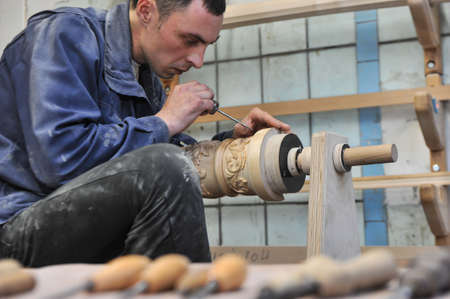 St. Petersburg, Russia - August 8, 2017: A new manufactory for the full cycle of production of a harp musical instrument. The wood carver enchants the base of the musical instrument.のeditorial素材