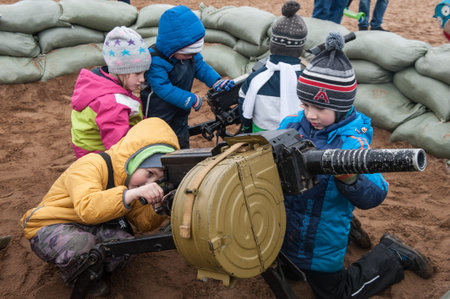 St. Petersburg, Russia - April 30, 2017: Children play with a machine gun at a military technology...