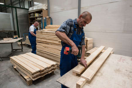 St. Petersburg, Russia - June 29, 2016: Two carpenters produce pallets for storage and transportation of furnitureのeditorial素材