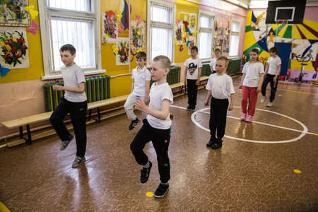 Leningrad region, Russia - May 12, 2017: schoolchildren in a rural school in a physical education class perform a warm-up exercise - walking on the spot.のeditorial素材