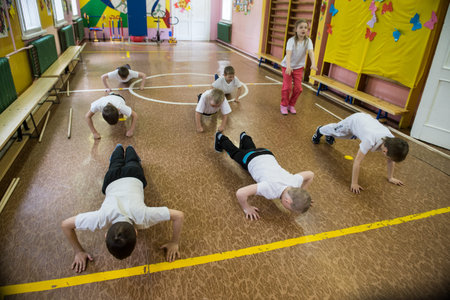 Leningrad region, Russia - May 12, 2017: Power exercise of push-up from the floor. Children in the...