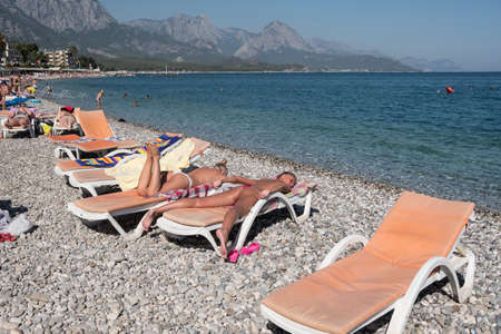 Kemer, Turkey - October 22, 2017: Tourists are resting on the beach of Kemer. Free sunbed in the foreground.のeditorial素材