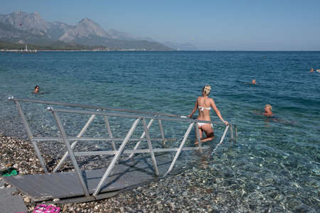 Kemer, Turkey - October 22, 2017: Tourists are resting on the beach of Kemer. In the foreground, a special path for entering the waterのeditorial素材