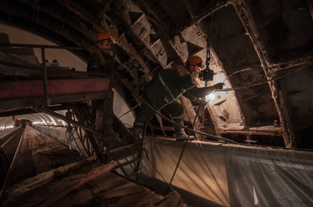 St. Petersburg, Russia - March 15, 2016: Repair of the underground escalator. Electricians make wiring in the underground mineのeditorial素材