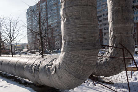 Laying of heat-insulated large diameter pipes for hot water supply during the construction of a residential area. Pipes are insulated with special materials. Are above the ground.の写真素材
