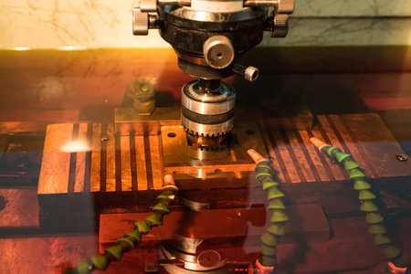 Electroerosive treatment of metallic form in a cooling dielectric liquid of red color. Manufacturing...