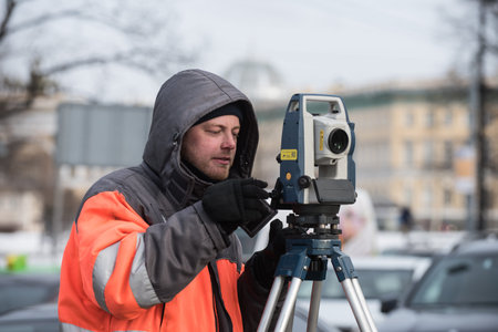 St. Petersburg, Russia - March 28, 2018: A young male surveyor makes the necessary measurements in...