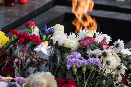 St. Petersburg, Russia -28 March 2018: Flowers and children's toys are laid to eternal fire on the Champ de Mars on the day of mourning and tragedy in Kemerovo, where people died in the Winter Cherry mallのeditorial素材