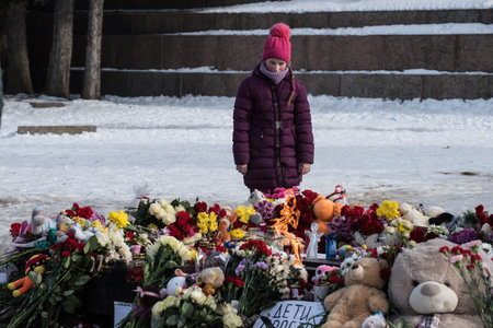 St. Petersburg, Russia -28 March 2018: Flowers and children's toys are laid to eternal fire on the Champ de Mars on the day of mourning and tragedy in Kemerovo, where people died in the Winter Cherry mallのeditorial素材