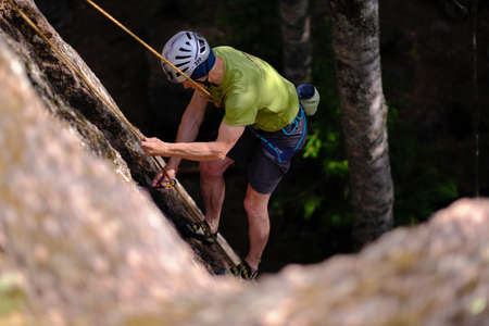 Leningrad region, Russia - June 23, 2018: Climbers during training sessions on overcoming rocky mountains on the rocks "Paltsevo". The climber overcomes steep areas with the help of equipment.のeditorial素材