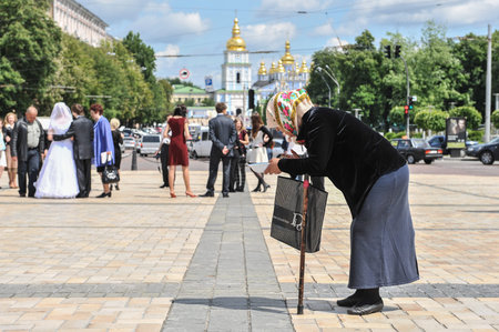 Kiev, Ukraine - May 23, 2009: At the weekend, the main street of the city Khreshchatyk becomes a pedestrian. Joyful people walk along the sidewalks and the roadway. A beggarly old woman asks for alms.のeditorial素材