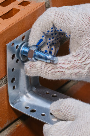 Stage of installation of a chemical anchor in a red building brick with cellular voids.  Fastening...