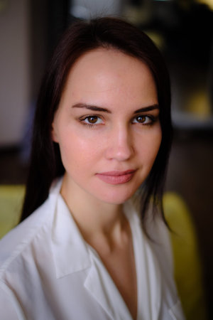 A young beautiful, pretty girl 25-30 years old looks into the lens. Close-up. Brown hair. Big brown...