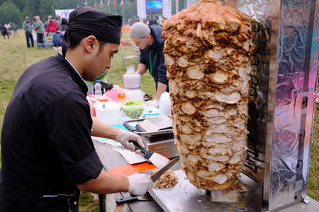 Leningrad Region, Russia - June 30, 2018: Sabantuy - the Peopleâs Tatar and Bashkir feast of the end of spring fieldwork. A man sells shawarma from meat.のeditorial素材