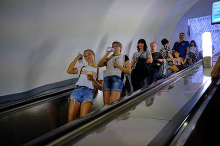 St. Petersburg, Russia - June 14, 2018: People on a subway escalator. Artificial light. Interior metro station.のeditorial素材