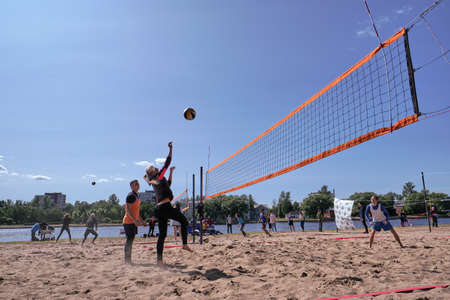 St. Petersburg, Russia-June 30, 2019: On the banks of the northern river in the city park of Europe, young people compete in volleyball. Tense moment.のeditorial素材