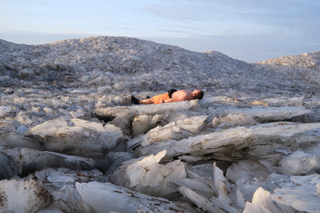 St. Petersburg, Russia - January 2, 2020: Tourists stroll along the coast of the Gulf of Finland. Sunny, fine day after a hurricane and an ice storm. Pieces of ice, open space, skyline. Russian crazy extremeのeditorial素材