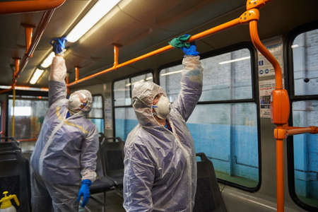 St. Petersburg, Russia - March 19, 2020: Disinfection of public transport as a preventive measure against the COVID-19 pandemic. Employees in special protective overalls handle the interior of tramのeditorial素材