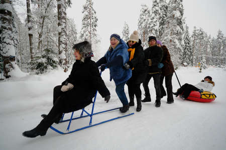 Saint Petersburg, Russia - January 17, 2019: A company of friends is riding on a beautiful snowy road. They have fun, laugh, great mood. Several peopleのeditorial素材