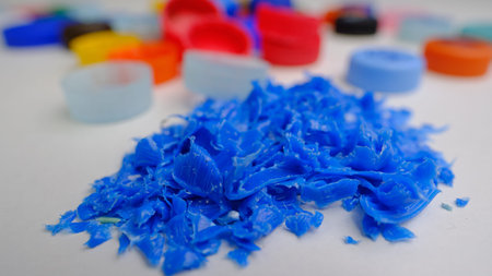 A crumb from various plastic waste - bottles, cans, boxes, as raw materials for processing in a small business. Multi-colored, bright, different, small. On a white backgroundの写真素材