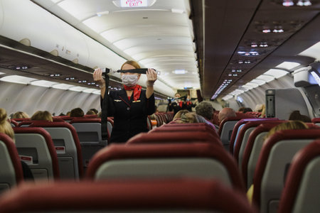 Saint Petersburg, Russia - November 13, 2020: A stewardess in a mask demonstrates to aircraft...