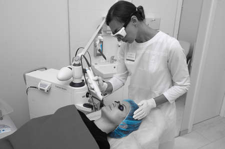 SAINT PETERSBURG-RUSSIA - JULY 24, 2017: The beautician conducts a procedure for laser rejuvenation of the facial skin of a young beautiful girl, the process of workのeditorial素材