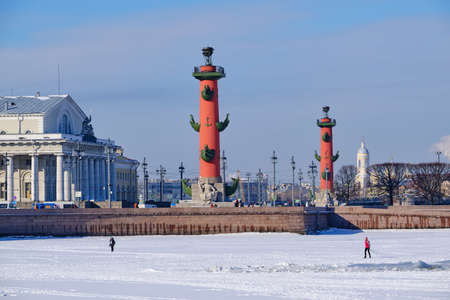Saint Petersburg, Russia - March 4, 2019: View of the rostral columns in winter, a man went out on the ice along the frozen Neva, an architectural landmark of the cityのeditorial素材