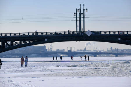 Saint Petersburg, Russia - March 4, 2019: View of the palace bridge in winter, a man went out on the ice along the frozen neva, an architectural landmark of the cityのeditorial素材