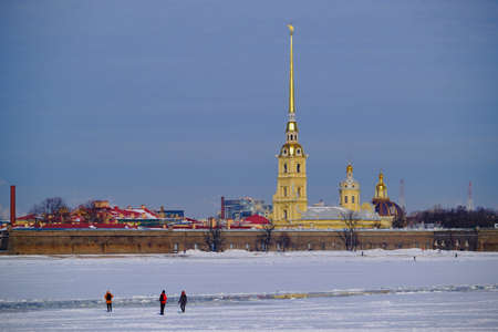 Saint Petersburg, Russia - March 4, 2019: View of the Peter and Paul Fortress in winter, a man went out on the ice through the frozen Neva, an architectural landmark of the cityのeditorial素材