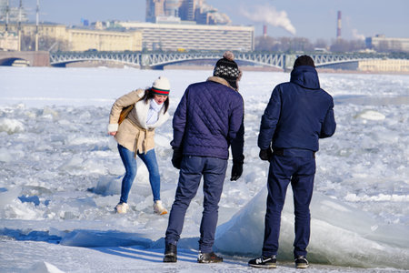 Saint Petersburg, Russia - March 4, 2019: People on a frosty winter day walk on the ice of the Neva...