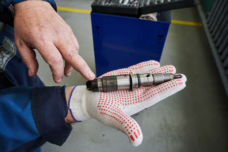 At the stand, the process of checking the operability and wear, the operational properties of the nozzle of a diesel internal combustion engine, close-up, car serviceの写真素材