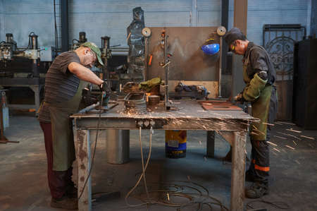 Production line for the manufacture of lampposts for city lighting. Section for manual grinding of products using a grinderのeditorial素材