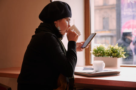 a girl of 25 years old in glasses and a dark beret in a medical mask to protect against coronavirus infection Covid-19の写真素材
