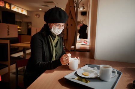 a girl of 25 years old in glasses and a dark beret in a medical mask to protect against coronavirus infection Covid-19の写真素材