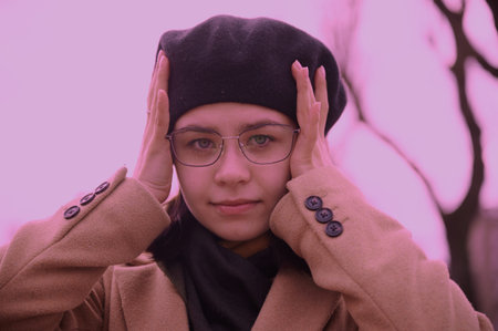 Portrait of a girl in a beret and glasses on the background of the city