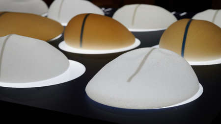 Silicone female breast implant is the main object of plastic surgery in human hands. Demonstration of the qualities of a medical objectの写真素材