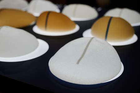 Silicone female breast implant is the main object of plastic surgery in human hands. Demonstration of the qualities of a medical objectの写真素材