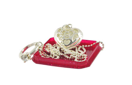silver jewelerry on red box cover over white surfaceの写真素材