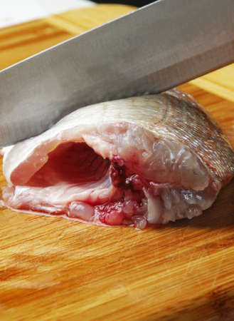 cutting fish on wooden boardの写真素材