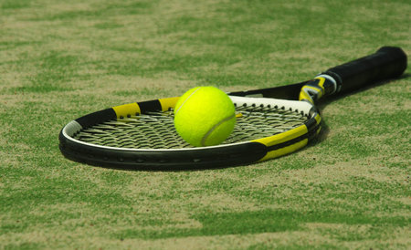 tennis racket with ball on court