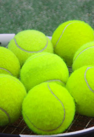 tennis racket with balls on courtの写真素材