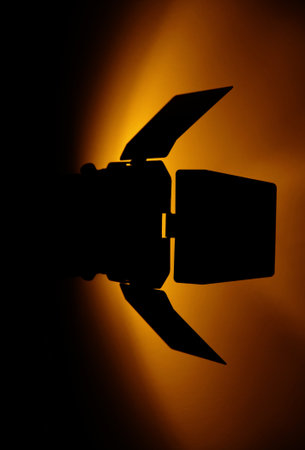 studio flash silhoutte with orange light on wallの写真素材
