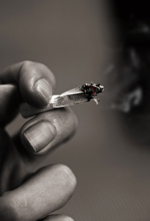 high contrast toned picture of hand with cigarette.shallow DOF